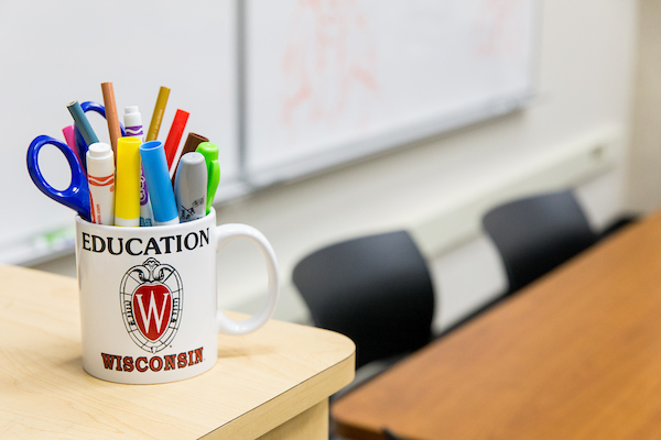 classroom with table and two chairs and a mug with pens