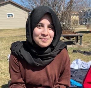 Portrait of Rabia Jan, a south-asian woman with brown eyes, wearing a headscarf and smiling.